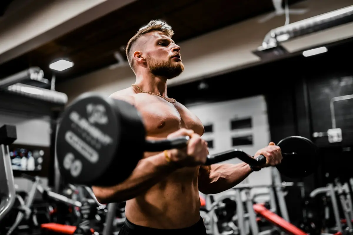 Sportaš izvodi pregib s EZ šipkom u teretani